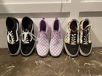Lot of three girls running shoes; black Vans lace-up, lavender checkerboard slip-on, and multi-color checkerboard high-top.