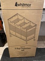 Box of Whitmor Supreme 3-Bag Organizer with line drawing of laundry sorter