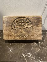 Front view of the lid showing detailed tree of life carving on natural wood keepsake box.