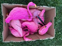 Top view of the boxed flamingo lawn ornaments showing five pink plastic flamingos with metal stakes packed inside a cardboard box.