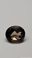 Close-up front angle photo of the 4.39ct oval cut natural Smokey Quartz gemstone showing dark brown to black color and faceted cut.
