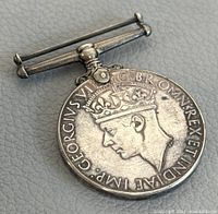 Front side of the George VI war medal showing King George VI profile and inscriptions.