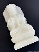White jade carved Guan Yin statue viewed from front, showing detailed facial features, hands, and lotus base.
