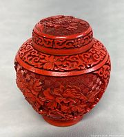 Front angle showing floral carvings and the rounded jar body with lid