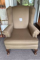 Front view of wingback armchair showing overall shape and condition