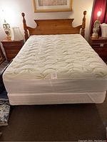 Assembled queen mattress, box spring, bed frame and headboard frontal view