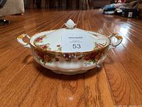Front view of the covered vegetable bowl showing the floral pattern and gold trim.