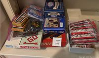 Photo showing Monopoly, Phase 10, Scrabble, Dominoes, and Rummy-O boxes along with a tin container for dominoes and some game cards.