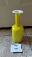 Front view of the yellow blown glass vase with white flared rim.