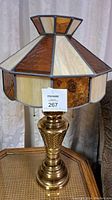 Full view of vintage stained glass lamp showing the brass base and the carmel, gold, and cream stained glass shade.
