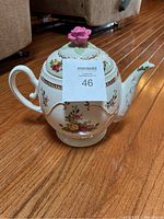 Porcelain teapot-shaped cookie jar with Old Country Roses floral design, gold trim, and pink rose lid.