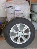 Single wheel assembly showing Michelin tire mounted on alloy rim with MaxSold lot tag in view