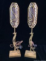 Front view of both lamps showing peacock motif and backplates