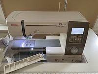 Close-up of machine head showing Janome Horizon branding, LCD screen and control panel