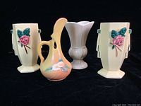 Four mid-century USA pottery pieces including a pair of McCoy vases, Roseville ewer, and Trenton TAC vase, displayed on black background showing full set.