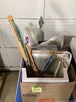 Box containing long wooden quilting frame bars, wooden hoop arch piece, mini sleeve ironing board and other long tools