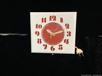 Front view of the square GE Telechron wall clock showing red dial with white hands and white frame with red cut-out numbers.