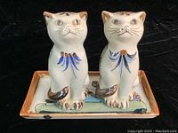 Front view of two cat salt and pepper shakers on a small rectangular tray, detailed hand-painted design and facial features visible.