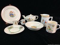 Overview photo of all 8 pieces showing various nursery rhyme children's dish items including teapot, creamers, plates, bowl, and cup with colorful illustrations.