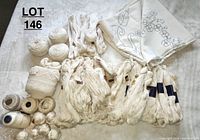 Lot showing multiple skeins and balls of off white and beige crochet yarn and fabric