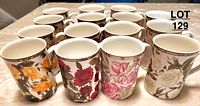 Front view of 15 rose printed fine bone china mugs arranged closely, showing various rose designs and colors: yellow, red, pink, white, and multicoloured.
