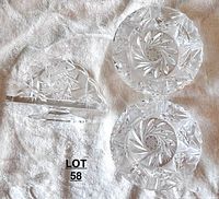 Lot overview showing the napkin holder and two ashtrays placed on a white cloth background, showing cut pinwheel designs on each item.