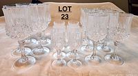 Full set of 17 glasses including 5 red wine, 6 white wine, and 6 liqueur glasses on beige cloth background.