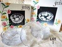 Photo showing 12 small dessert plates stacked, with original boxes for serving bowl and platter in background