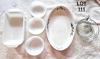 Photo showing the full set of items including 3 milk glass bowls, an oval Woodhill bakeware platter with floral design, a clear glass juicer, and a white glass loaf pan.