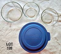 Top view of four glass bowls: three clear glass bowls and one large clear glass bowl with blue Anchor-branded plastic lid.
