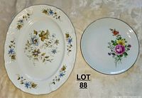 Top view showing two plates: Ridgeway Ironstone platter on the left with scalloped edges and floral pattern, and German Democratic Republic flower plate on the right with colorful central flowers.