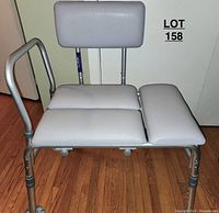 Full view of the bathtub/shower chair showing padded seat, backrest, one armrest and adjustable legs.