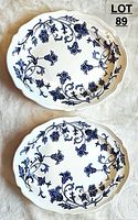 Two oval ironstone platters with blue floral Windsong pattern on white background, top view.