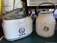 White Think Kitchen brand toaster and kettle with slight scratches on surfaces placed on a blue table.