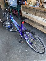 Full view of purple/teal Movelo bike showing frame, tires, saddle, and handlebars