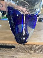 Close-up of the front of the blue glass face sculpture showing cobalt blue and clear glass textures.