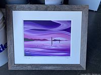 Front view of framed print depicting a purple-hued landscape with reflections and mountains titled 'Lavender Light' by YL Acheson.