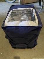 View of the comforter inside a navy blue fabric storage bag showing the full package shape and size