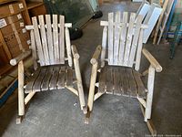 Front view of two rustic cedar rocking chairs showing slatted back and seat with rounded armrests and curved rocker bases.