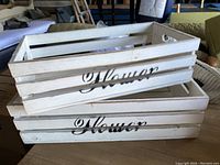 Two small white painted wooden crates stacked, both stamped 'Flower'.