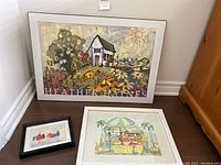 Three artworks grouped on the floor: large Heather Haynes plaque on back, two smaller framed watercolors in front.