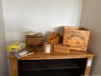 Overview photo of all wooden boxes, pencil holders, spool, mahjong box and hanging shelf on wooden surface