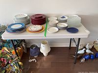 Wide photo showing the Lifetime foldable table set up with various plates on top, highlighting its size and condition.