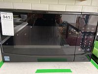 Front view of black Kenmore microwave oven showing the digital keypad and door with glass panel.