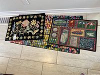 Three mats stacked with floral embroidered mat on top and two colorful golf themed mats underneath.