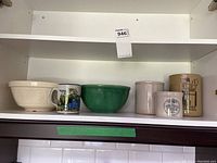 Overview of six items on shelf including two bowls, three utensil crocks, and one mug