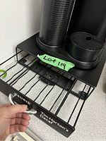 Open metal pull-out drawer at the base of the coffee maker labeled 'Tim Horton's Decaf' for coffee pod storage.