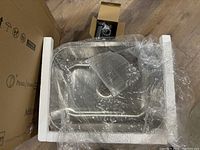 Photo showing top view of the stainless steel kitchen sink wrapped in bubble wrap and foam supports.