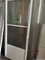 Full view of white aluminum framed screen door with glass and screen panels.
