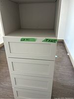 Front view showing four drawer fronts and two open shelves.